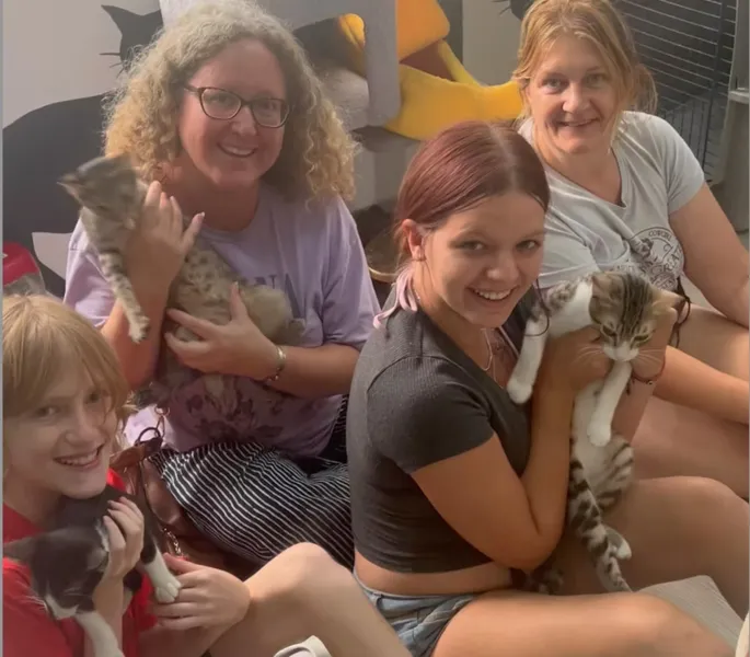 Visitors enjoying time with rescue cats at Purr Vida Lounge